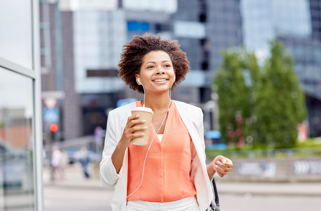a confident woman smiling while holding a coffee cup