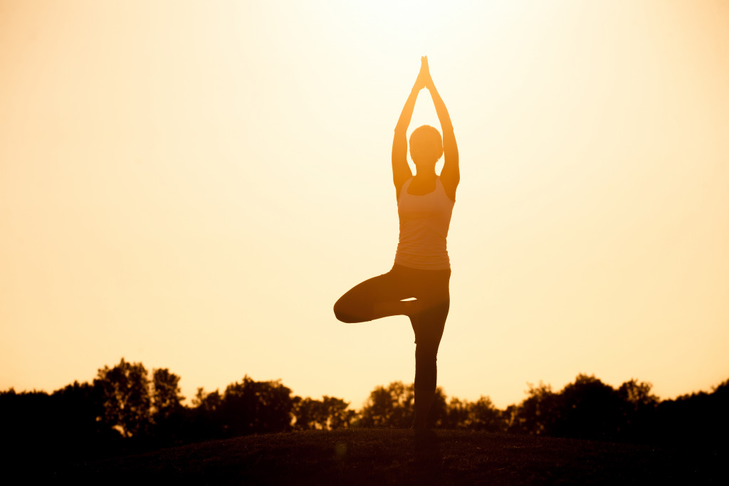 healthy and balanced woman in yoga pose at the sunset outdoors