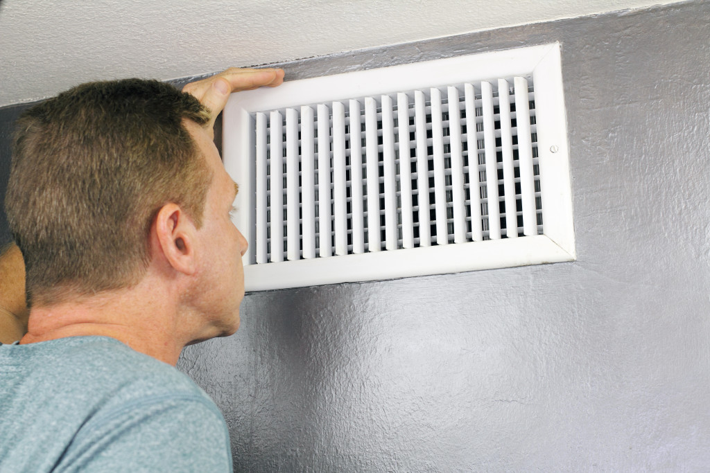 man checking ventilation of his home