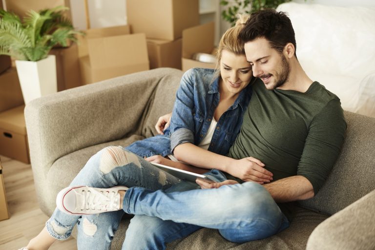 couple sitting on sofa of new home